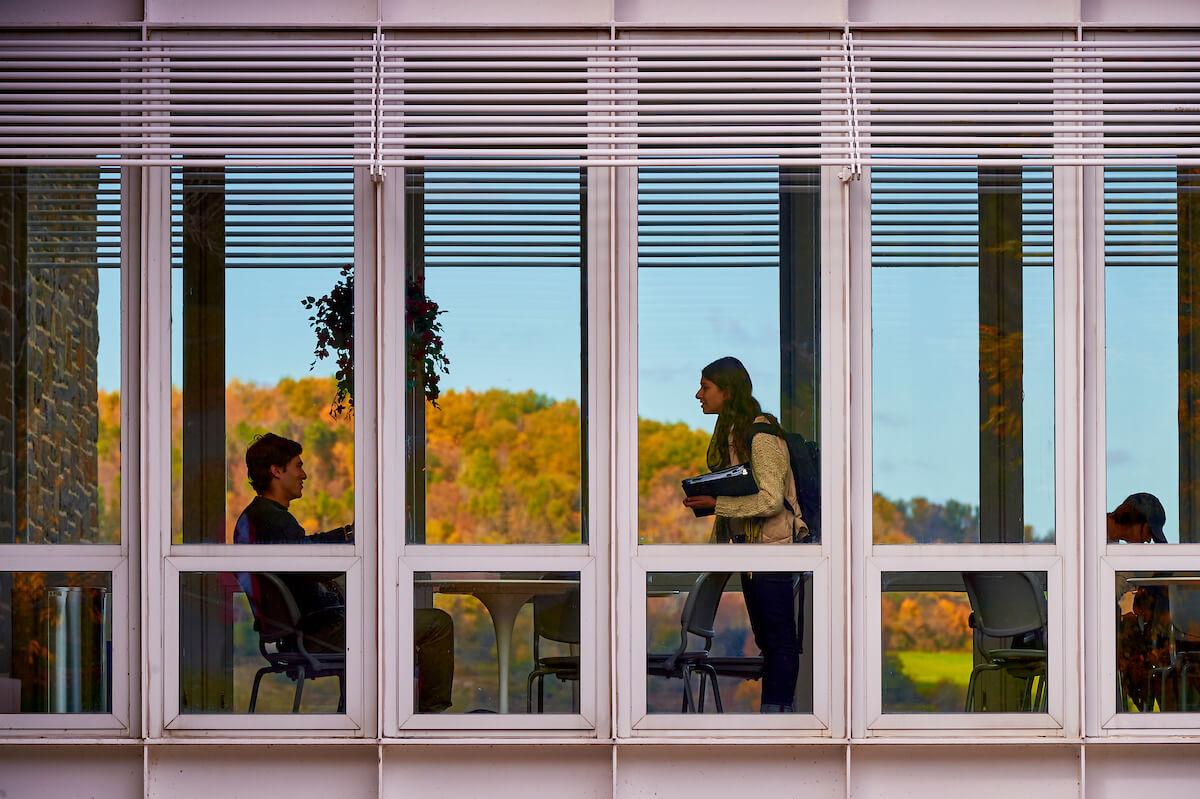 Students meet in the lounge that bridges the two wings of Persson Hall during an autumn day
