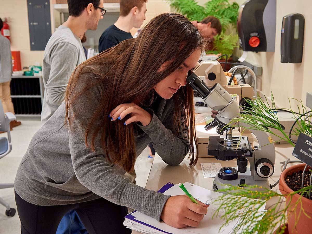 Student works at a microscope in her biology lab